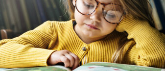 jeune fille en train de lire un très gros livre de contes