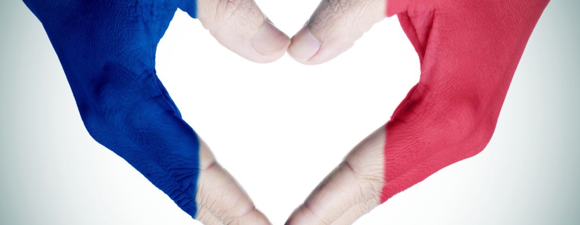 Deux mains jointes formant un coeur, colorées aux couleurs bleu blanc rouge du drapeau français