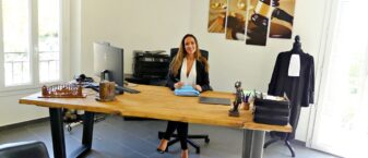 avocate souriante assise à son bureau