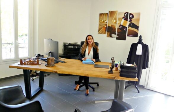 avocate souriante assise à son bureau - Agrandir l'image, fenêtre modale