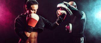 un homme une femme gantés en position d'affrontement de boxe