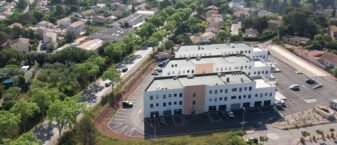trois bâtiments blanc et ocre au milieu d'un espace mi rural mi urbain
