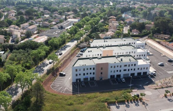 trois bâtiments blanc et ocre au milieu d'un espace mi rural mi urbain - Agrandir l'image, fenêtre modale