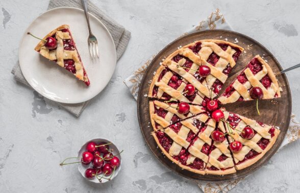 tarte à la cerise dans un plat avec une part coupée déposée dans une assiette à côté, et un petit ramequin de cerises - Agrandir l'image, fenêtre modale