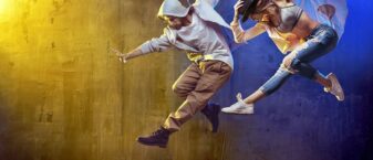 un homme et une femme en plein saut pendant une danse de hip hop.