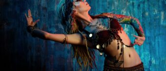 photo de danseuse orientale en action, sur fond bleu