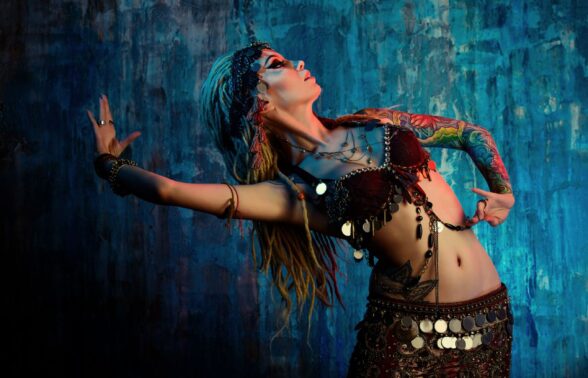 photo de danseuse orientale en action, sur fond bleu - Agrandir l'image, fenêtre modale