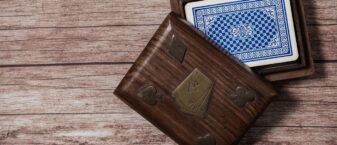 Table en bois sur laquelle est disposée une boîte, à l'intérieur de laquelle l'on voit un jeu de cartes bleu et blanc
