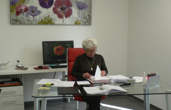 femme assise à son bureau consulte des dossiers - Agrandir l'image, fenêtre modale