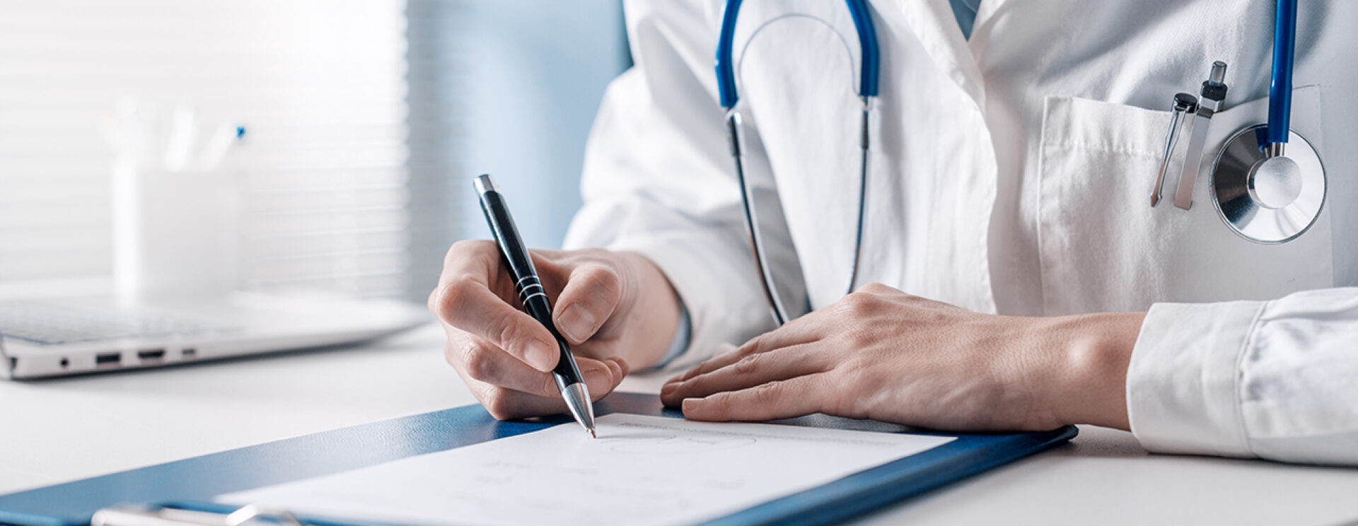 médecin assis à son bureau rédige une prescription sur ordonnance.