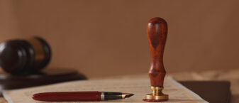 bureau de notaire avec stylo plume, acte de propriété et seau.