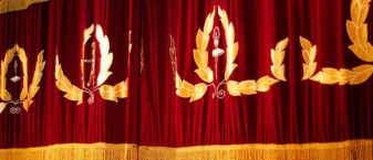 Rideau de scène de théâtre rouge et or.