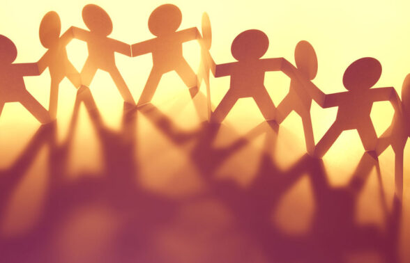 photo jaune orangée d'un papier découpé avec bonshommes qui se tiennent par la main - Agrandir l'image, fenêtre modale